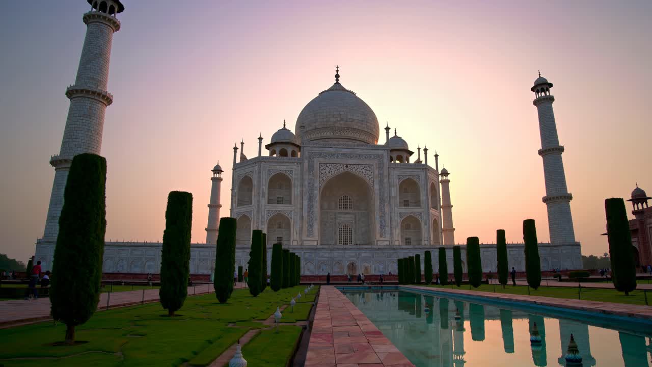 A video showcasing the Taj Mahal at sunset, captured from a low angle, highlighting its majestic