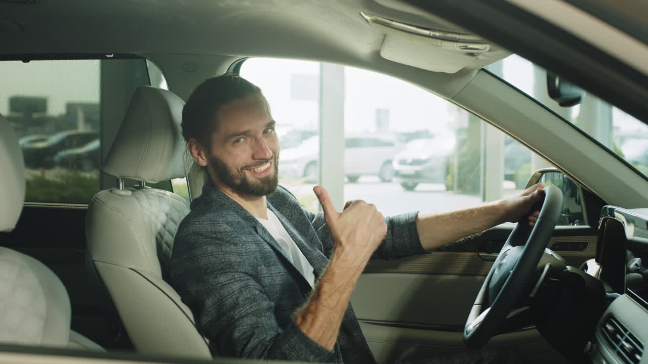 hombre conduciendo un coche nuevo en una sala de exposiciones