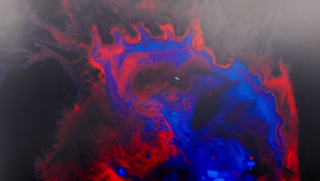 alcohol ink swirling in vibrant red and blue, abstract macro shot with cosmic feel
