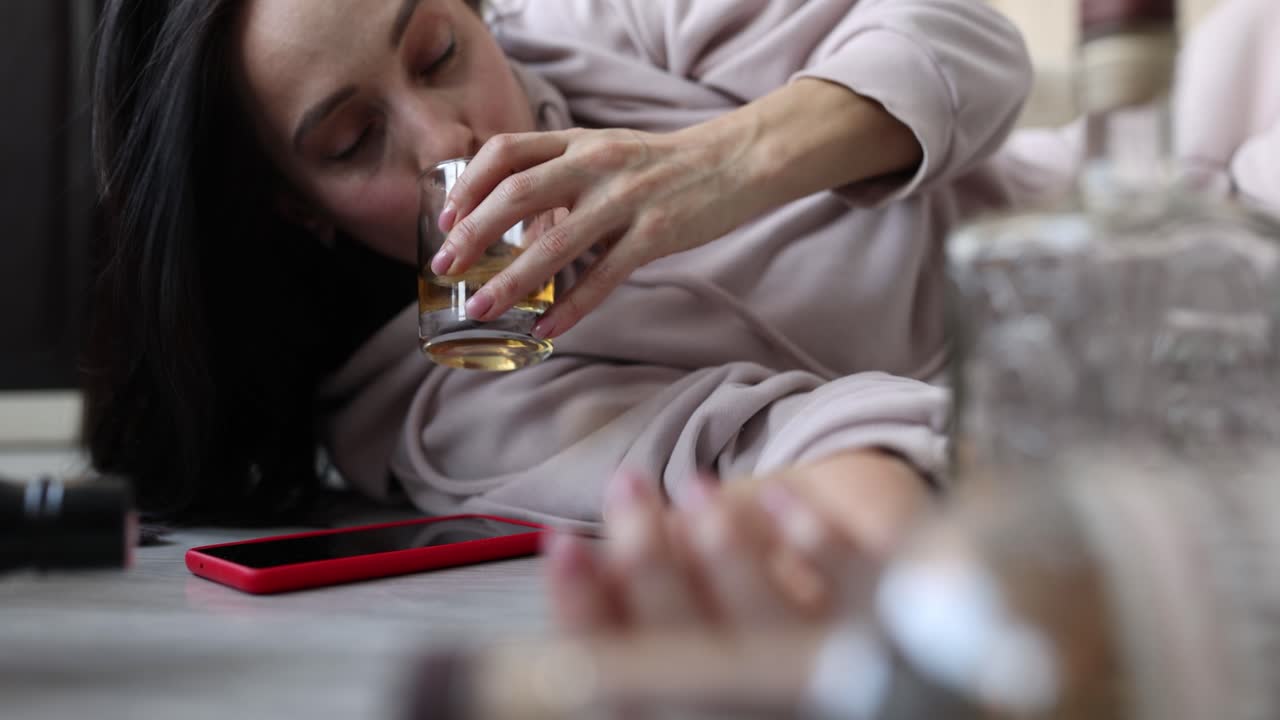 Woman drinking alcohol on the floor
