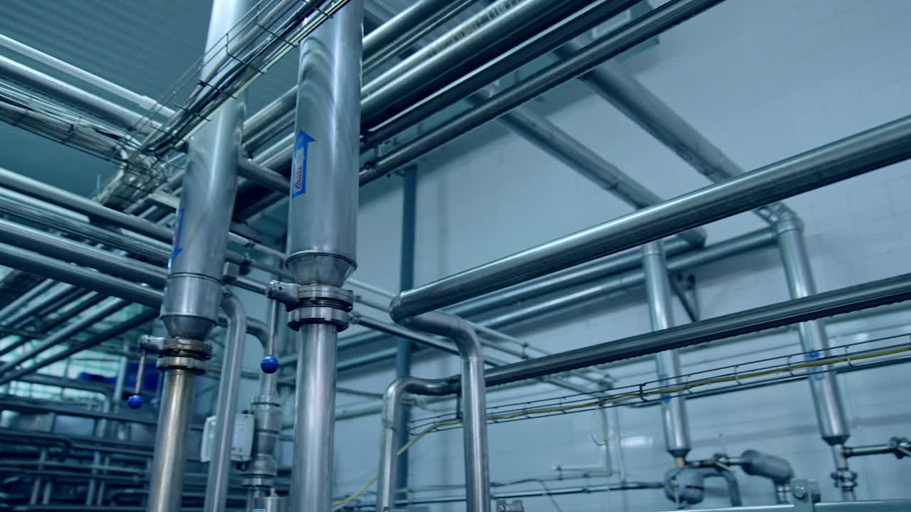 Moderne metallutstyr. Industrielt utstyr i meierifabrikk med metallrør.