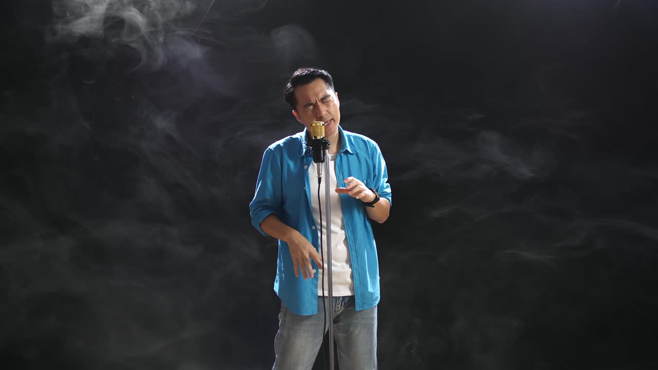 hombre cantando en el micrófono en el escenario