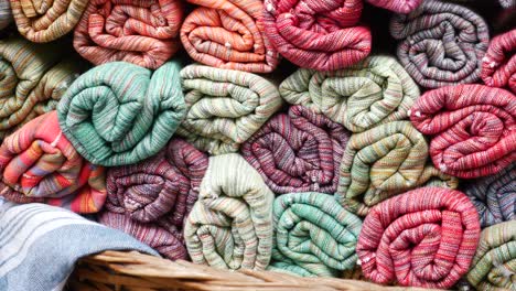 rollos de tela de colores apilados en una canasta