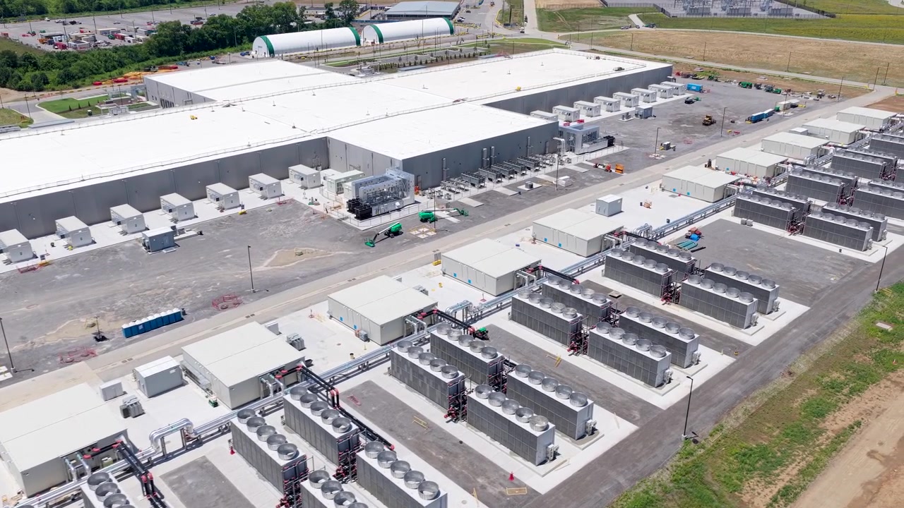Metas massive datacenterkompleks i Gallatin, stor serverbygning med omfattende rækker af industrielt køleudstyr, luftfoto med sporing