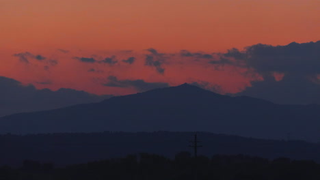 4K Timelapse of a sunset with clouds tinged with pink at the goldenhour. In the background mountains