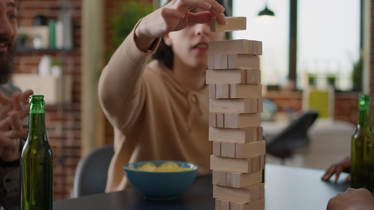 Happy people having fun with wooden tower on table