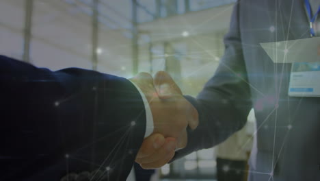 animation of network of connections over mid section of two businessmen shaking hands at office
