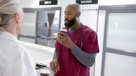 Diverse-male-and-female-doctors-in-discussion-drinking-coffee-in-hospital,-slow-motion