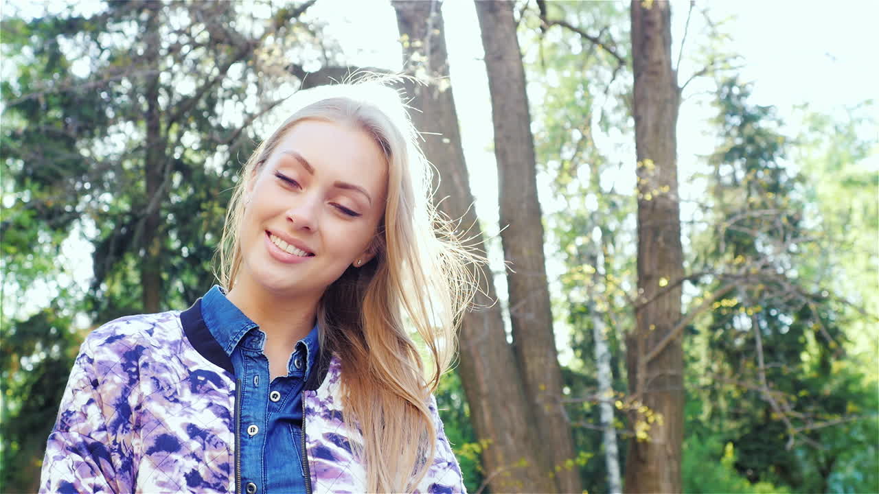 портрет привлекательной женщины улыбается и флиртует на камеру весна в городском парке hd vid