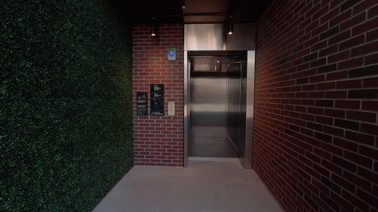 Real time static shot of elevator doors opening, pausing, and closing in covered walkway