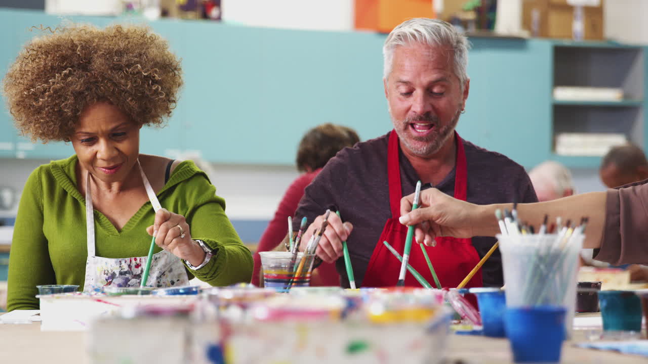 커뮤니티 센터에서 미술 수업에 참석하는 성숙한 학생들의 초점 촬영