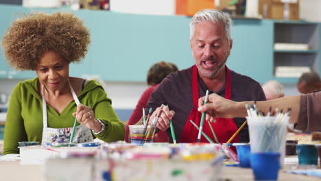 pull focus shot of mature students attending art class in community centre