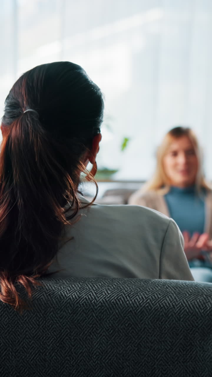 Kvinde der lytter til en anden kvinde i en professionel samtale