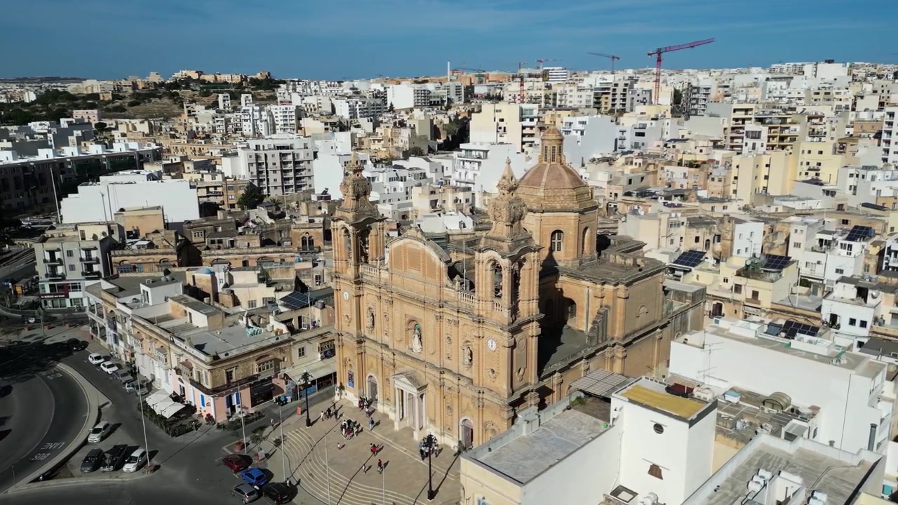 Filmato cinematografico con drone che mostra una cattedrale storica che si affaccia sul porto di Malta.