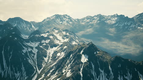 aerial over valley with snow capped mountains in distance