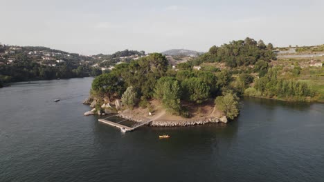 beautiful small pier near island of love in castelo de paiva, aerial orbit view