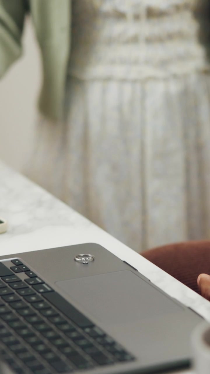 Woman Placing Engagement Ring on Laptop