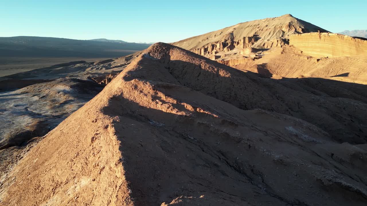 Drone shot of Valle de la Luna with long desert shadows and glowing ridgelines, evoking an extraterrestrial landscape