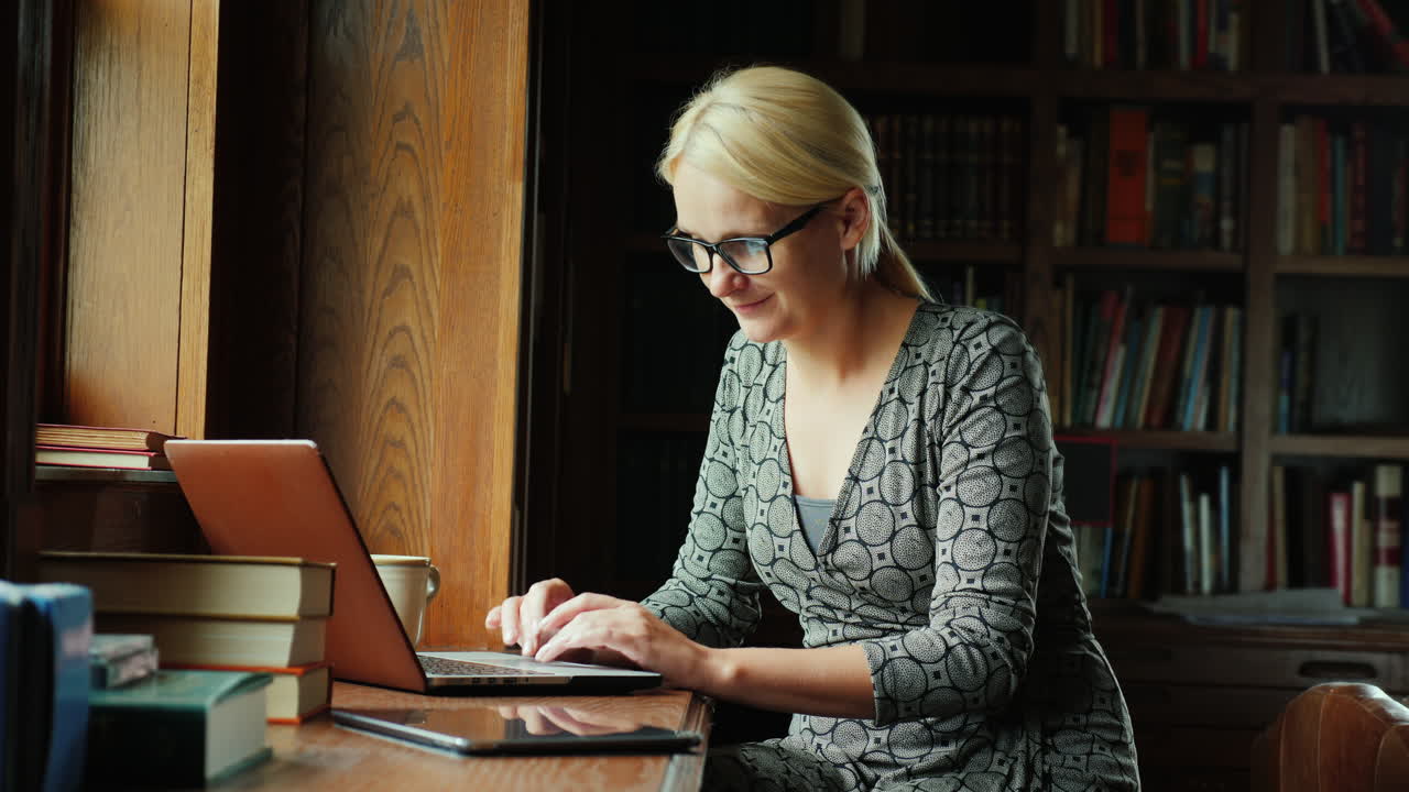 Kvinde bruger bærbar computer i bibliotek