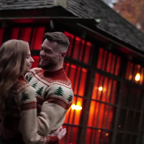 joyful couple having date outside the city. happy couple dancing, hugging and laughing at the rural manor. man and woman having fun at the backdrop of beautiful old wooden house