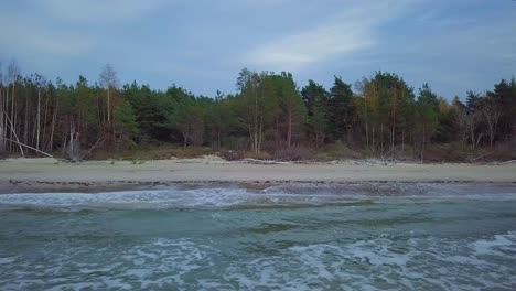 Beautiful-aerial-establishing-view-of-Baltic-sea-coast-on-a-sunny-evening,-sunset,-golden-hour,-beach-with-white-sand,-coastal-erosion,-climate-changes,-wide-angle-drone-dolly-shot-moving-right