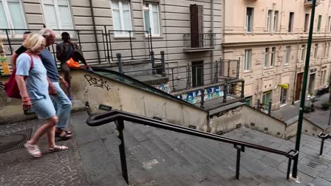 tourists walking down stairs in naples, italy