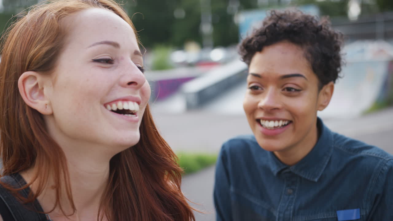 Two Female Friends Meeting In Urban Skate Park