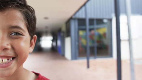 in a school corridor, a young biracial student smiles brightly with copy space