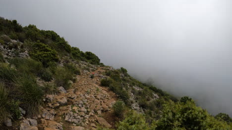 4k static shot of a rocky path on a mountain in a thick fog clouds at la concha, marbella, spain