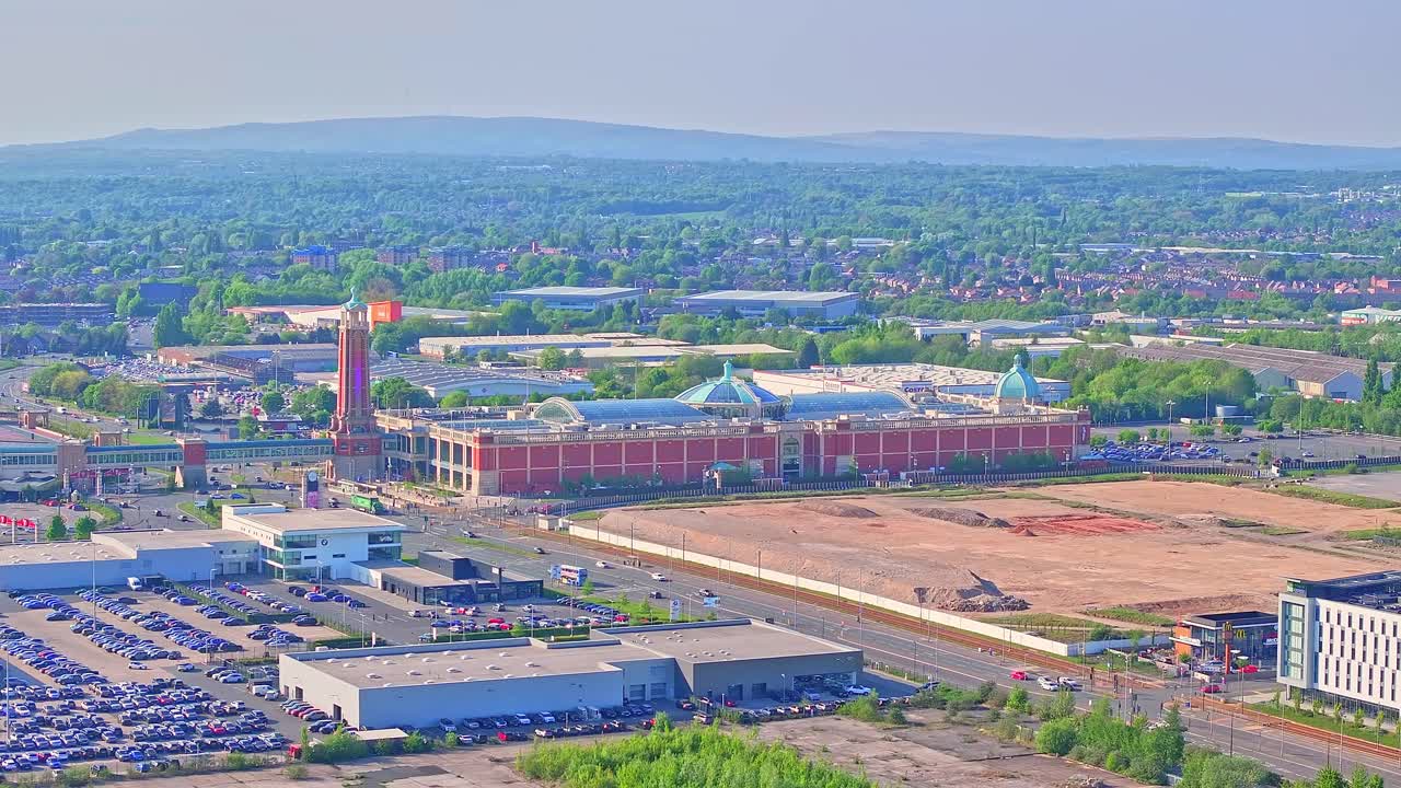 Dolly in drone shot of Trafford Centre large indoor shopping centre during the day in Trafford Park, Greater Manchester, England