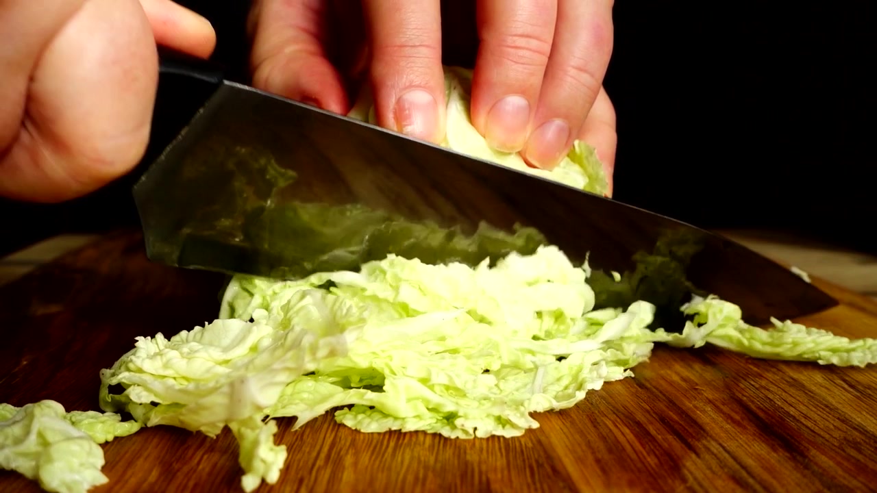 料理人が包丁で白菜を切る。スローモーション