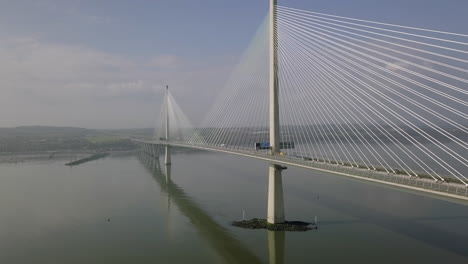 aerial footage of traffic travelling across the queensferry crossing bridge at south queensferry on a sunny day in west lothian, scotland