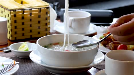 person eating noodle soup at a restaurant