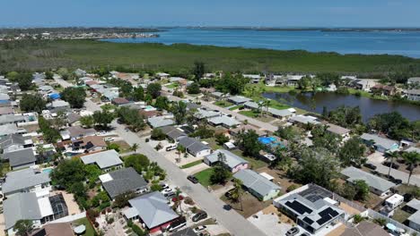 aerial view of cortez, florida, showing coastal community. quaint homes are nestled among lush greenery, with beautiful waterways in background. suburb district with greenery and seascape.
