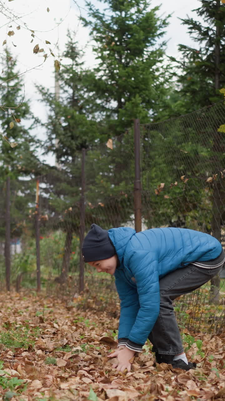 joven y su sobrino jugando alegremente al aire libre mientras ella rocia el follaje seco de otoño sobre ellos, ambos riendo y disfrutando del momento en medio del paisaje natural de otoño