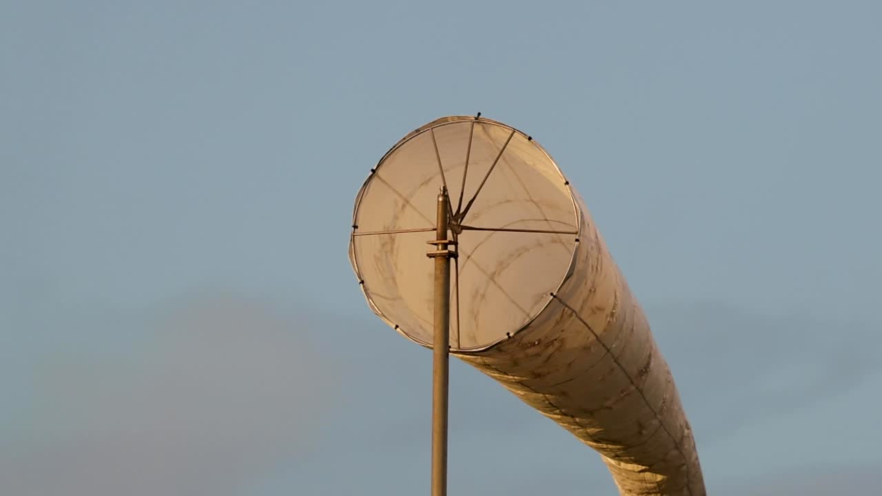 Eine detaillierte Nahaufnahme eines weißen Stoff-Windsacks, der sich im Wind bewegt
