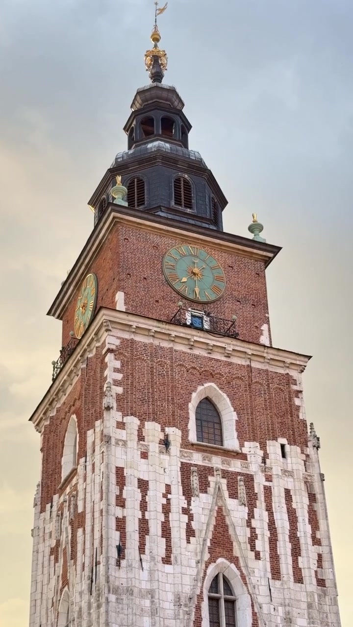 Filmato verticale in 4K che guarda verso l'alto la Torre del Municipio a Cracovia, Polonia, evidenziando lo storico punto di riferimento gotico e i dettagli architettonici