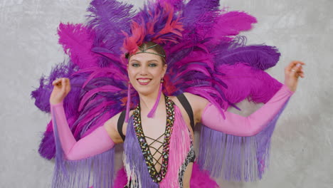 young pretty cabaret girl moving and dancing in feather gown