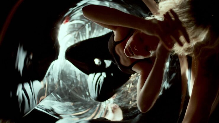 Woman Sitting in Mirrored Room with Swirling Abstract Reflections