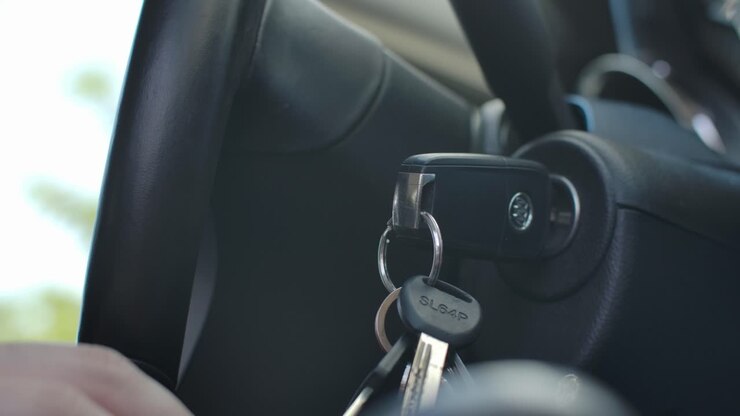 La mano di un uomo che inserisce la chiave in un'auto e accende il motore