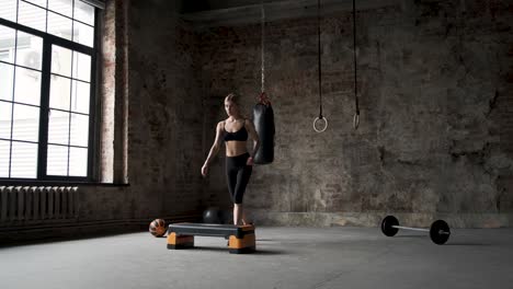 fit girl doing aerobic workout in gym. caucasian woman trains lose weight indoors