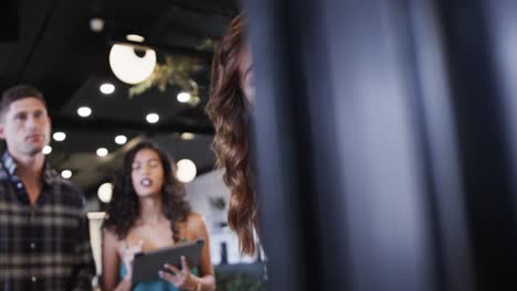 diverse creative colleagues in discussion making notes on glass wall in office, slow motion