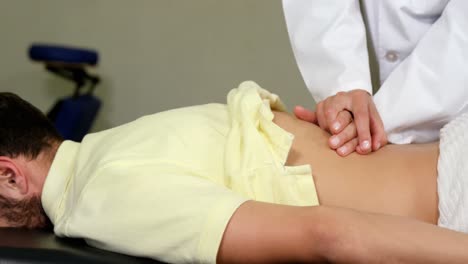 fisioterapeuta mujer dando masaje al paciente masculino