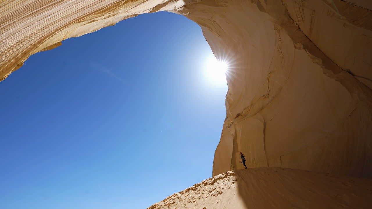 Female Hiker Walking on Sand Dune in Great Chamber, Amazing Natural Landmark in Grand Staircase National Monument, Utah USA