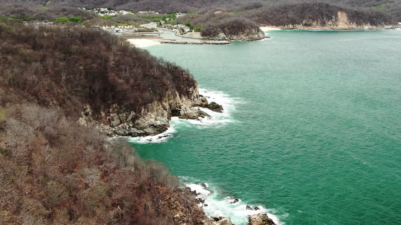 olas sobre las rocas en la playa de huatulco