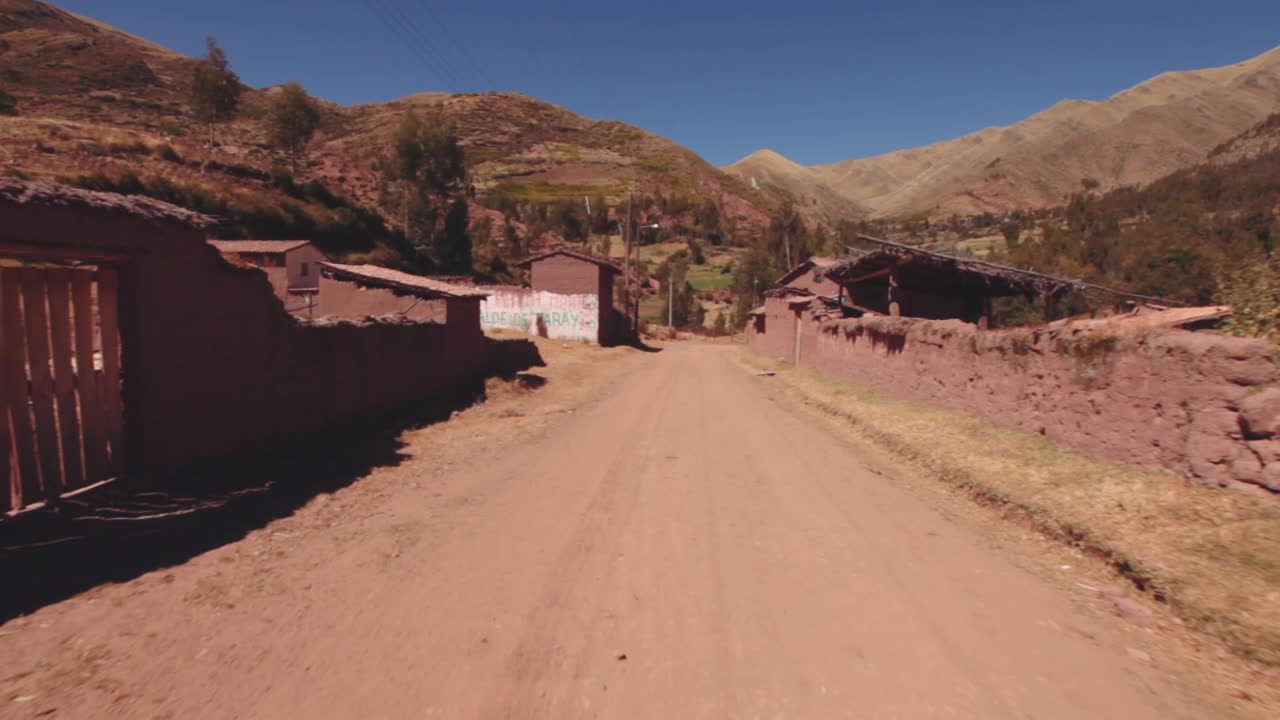 casas y edificios de adobe alineados en un camino de tierra en un pequeño pueblo peruano