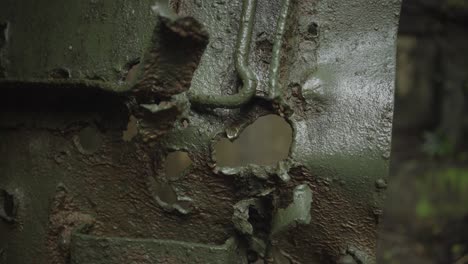 closeup pivoting shot of bullet holes in a bunker door on corregidor island