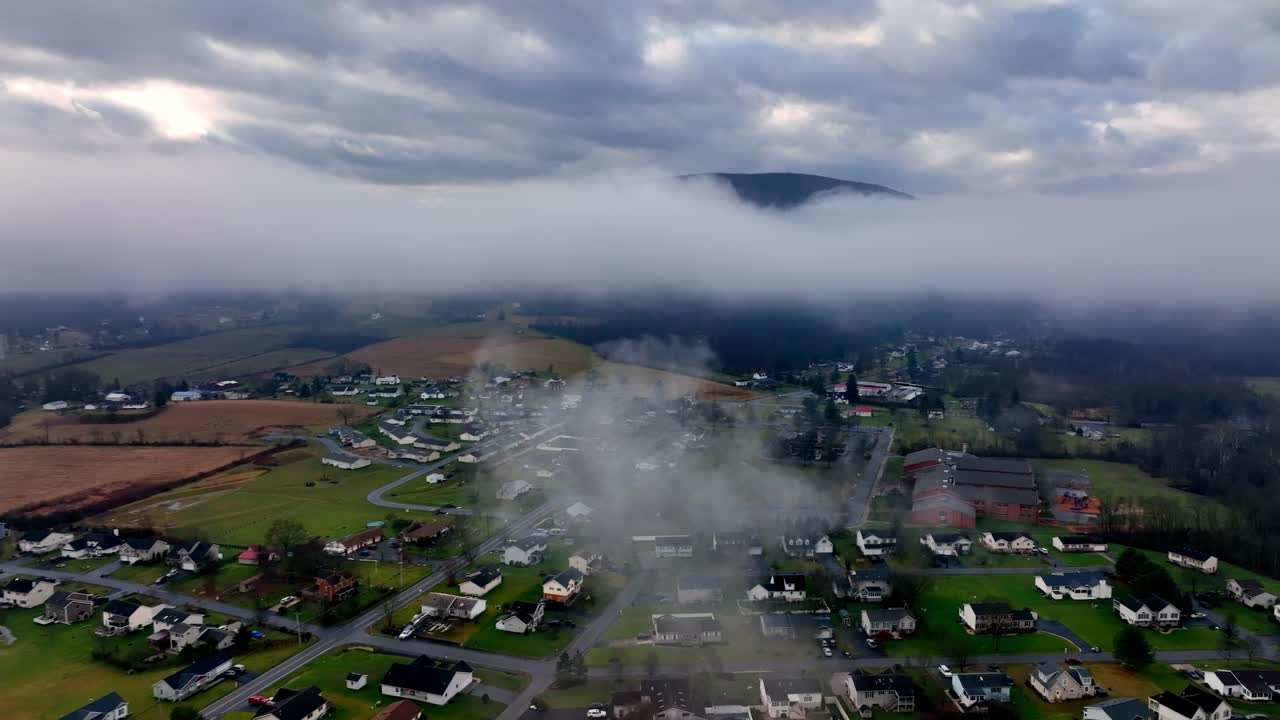 Aerial drone footage within the clouds over a rural community
