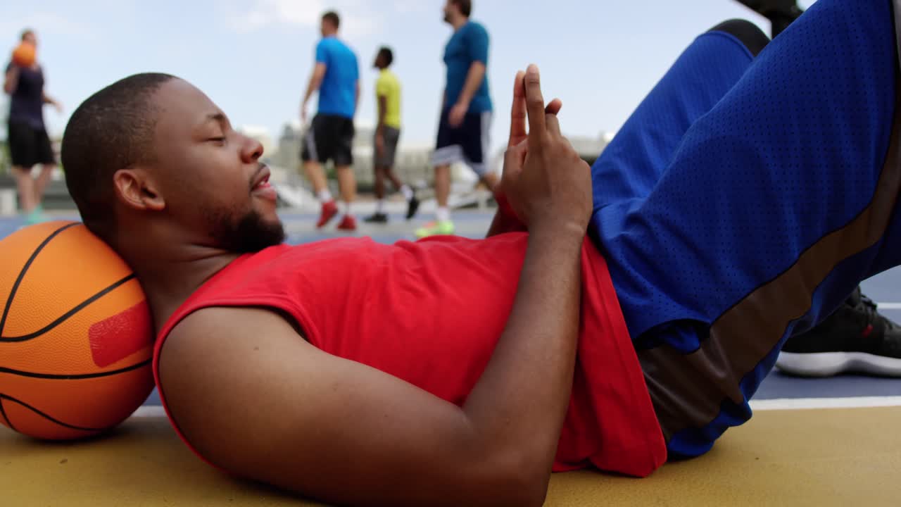 jugador de baloncesto usando teléfono móvil 4k