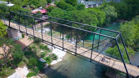 drone footage of the historic faust street bridge in new braunfels, texas that goes over the guadalupe river near interstate 35